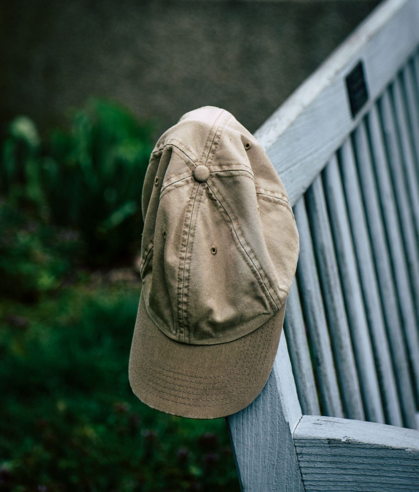 Builder Cap – keps i khaki på ett vitt räcke